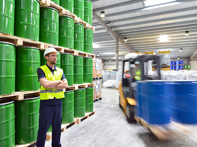 Eine Gruppe von Arbeitern in der Logistikbranche arbeitet in einem Lager mit Chemikalien